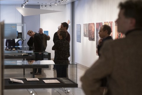 Foto von der Vernissage - Besucher betrachten eine Vitrine