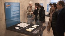 Foto von der Vernissage - Besucher betrachten eine Vitrine