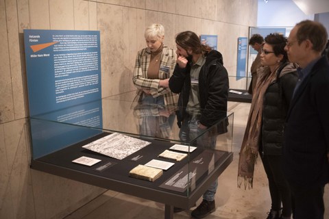 Foto von der Vernissage - Besucher betrachten eine Vitrine