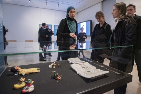 Foto von der Vernissage - Besucher betrachten eine Vitrine