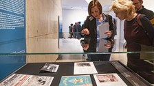 Foto von der Vernissage - Besucher betrachten eine Vitrine