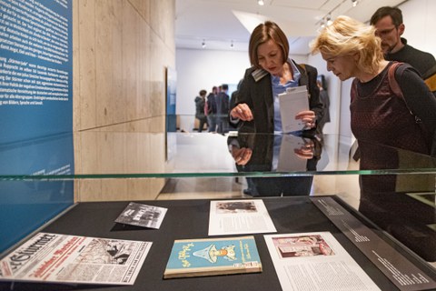 Foto von der Vernissage - Besucher betrachten eine Vitrine
