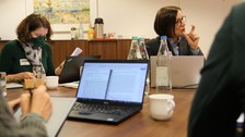 Menschen sitzen in einem Konferenzraum um einen Tisch