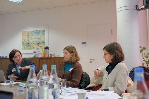 Menschen sitzen in einem Konferenzraum um einen Tisch