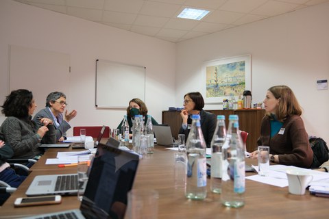 Menschen sitzen in einem Konferenzraum um einen Tisch