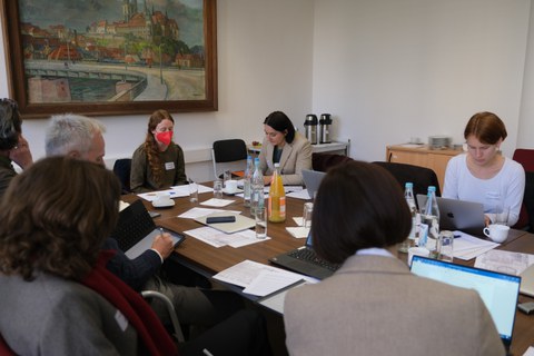Menschen sitzen um einen Tisch