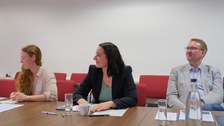 Menschen sitzen an einem Tisch und diskutieren miteinander