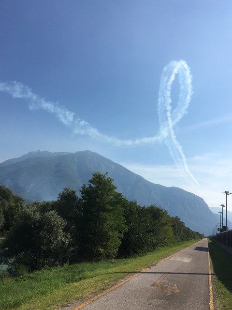 Kondensstreifenschleife über den Bergen von Trento.
