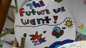 Photo with a circular white picture, which is colorfully painted. In the upper half is written in different coloured letters “The future we want”.