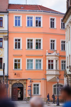 Ansicht des Hauptgebäudes des IHI Zittau. Es ist eine rosa gestrichene Barockfassade.