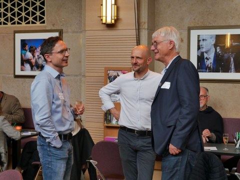 IHI-Alumni Landrat Dr. Stephan Meyer (Mitte) im Gespräch mit IHI-Direktor Professor Claus und einem weiteren Alumnus im Theaterfoyer