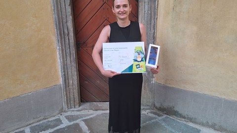 Lisa Junge hält die erhaltenen Preise in den Armen und steht im Innenhof der Burg Grabštejn