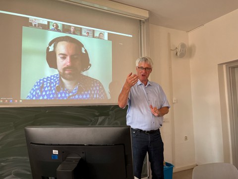 Herr Professor Thorsten Claus, Direktor des IHI Zittau, bei seinem Vortrag im Rahmen der Tagung "Zukunft Alter". Im Bildhintergrund ist die Videokonferenz zu erkennen, die zugleich läuft.