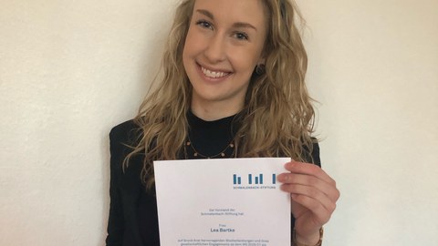 Lea hält ihr Stipendium-Zertifikat