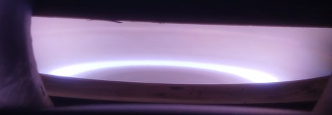 Ein blassviolett gleichmäßig leuchtendes Plasma einer Sputteranlage.