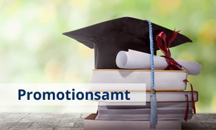 Schriftzug Promotionsamt, Doktorhut und Büchr im Hintergrund