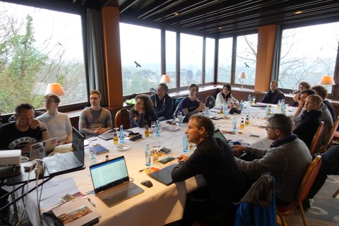 Several people sitting at a conference table and discussing.