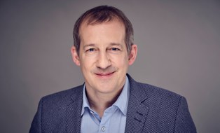 Lächelnder Mann mit Sakko und Hemd
