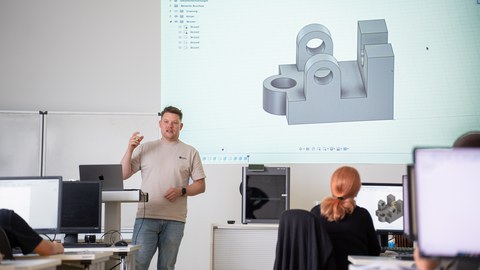 Mann hält einen Vortrag vor einer Gruppe