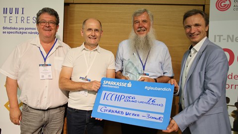 Foto der Übergabe des Roland-Wagner-Preis an Herrn Weber. Zu sehen sind v.l.nr. Klaus Höckner (Hilfsgemeinschaft der Blinden und Sehschwachen Österreichs), Klaus Miesenberg, Gerhard Weber und Dr. Ronald Bieber.