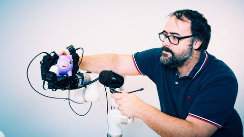 Portrait Prof. Roberto Calandra mit Roboterhand