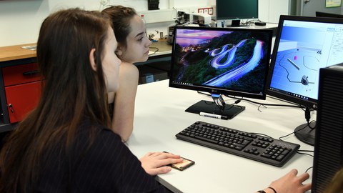 Zwei Schülerinnen zum Girl'sDay 2018 am Rechner, zwei Display mit Visualisierungen