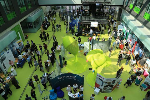 Foyer des Andreas-Pfitzmann-Baus zur OUTPUT.DD mit Präsentationsständen und Besuchern