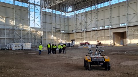 Testhalle des SLM mit Besuchergruppe und Wartog im Vordergrund