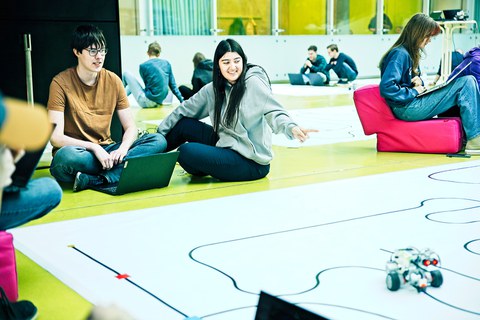 Studierende vor Planeten des RoboLabs im Foyer des APB 