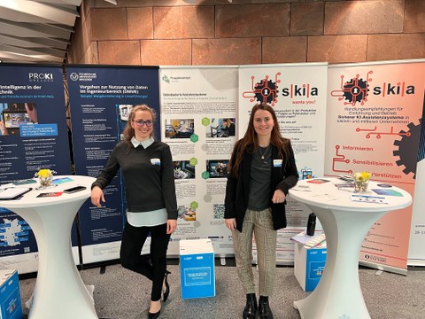 Kolleginnen vor dem CIMTT-Stand, im Hintegrund Roll-ups