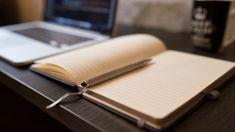 Arbeitsplatz mit Notebook und Notizheft