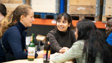 Female students sit at the table and chat animatedly.