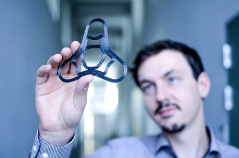 ILK-Wissenschaftler Andreas Borowski prüft ein generativ gefertigtes endlosfaserverstärktes CF-PEEK-Bauteil 