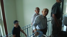 Drei Männer gehenh eine Treppe hinauf.
