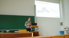 Vortragender Paul Weber mit Präsentation im Hintergrund.