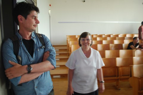 Eine Frau und ein Mann gehen durch den Hörsaal.