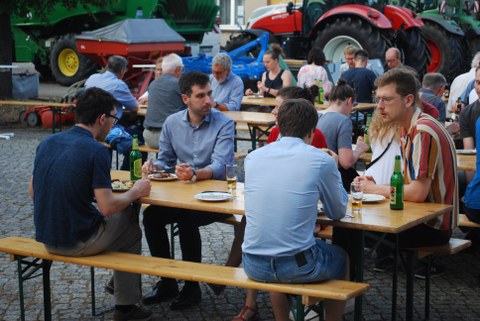 Foto von Menschen auf Bierbänken.