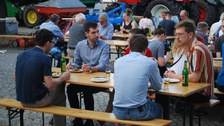 Foto von Menschen auf Bierbänken.