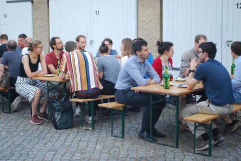 Foto von Menschen auf Bierbänken.