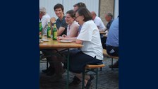 Foto von Menschen auf Bierbänken.