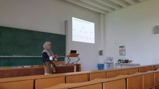 Eine Frau hält in einem Hörsaal einen Vortrag.