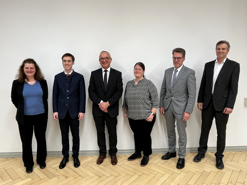 Gruppenbild mit 2 Frauen und 4 Männern in Businessoutfits.