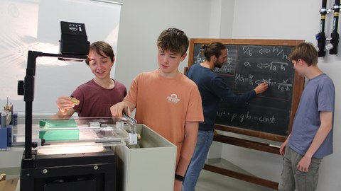 Schülerpraktikanten bei der Vorbereitung eines Demonstrationsversuchs zur Flachwasseranalogie, v.l.n.r.: Paul Botton, Max Bruch, Erik Frense (Betreuer), Philipp Müller     