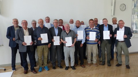 Group of elderly men holding their diploma certificate of honor