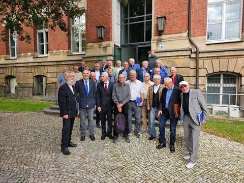 Group of elderly men in front of main entrance of ZEUNER-Bau