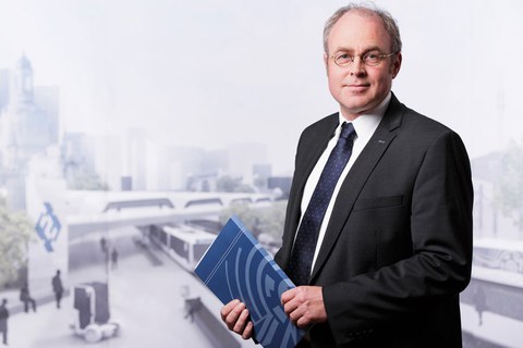 Foto von Professor Jochen Fröhlich vor dem Hintergrund einer virtuellen Stadtlandschaft