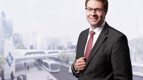 Foto von Professor Christoph Leyens vor dem Hintergrund einer virtuellen Stadtlandschaft