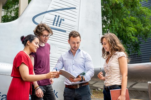 Auf dem Bild sind Studierende des Maschinenbaus an der TU Dresden zu sehen, die in einer Praxissituation in der Luft- und Raumfahrttechnik fotografiert worden