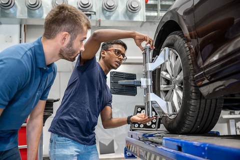 Auf dem Bild ist ein ingenieur an einem Auto zu sehen