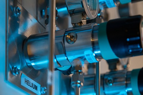 Blick auf ein Detail einer technischen Anlage, links im Bild ist an der Maschine der Begriff "Helium" zu lesen.